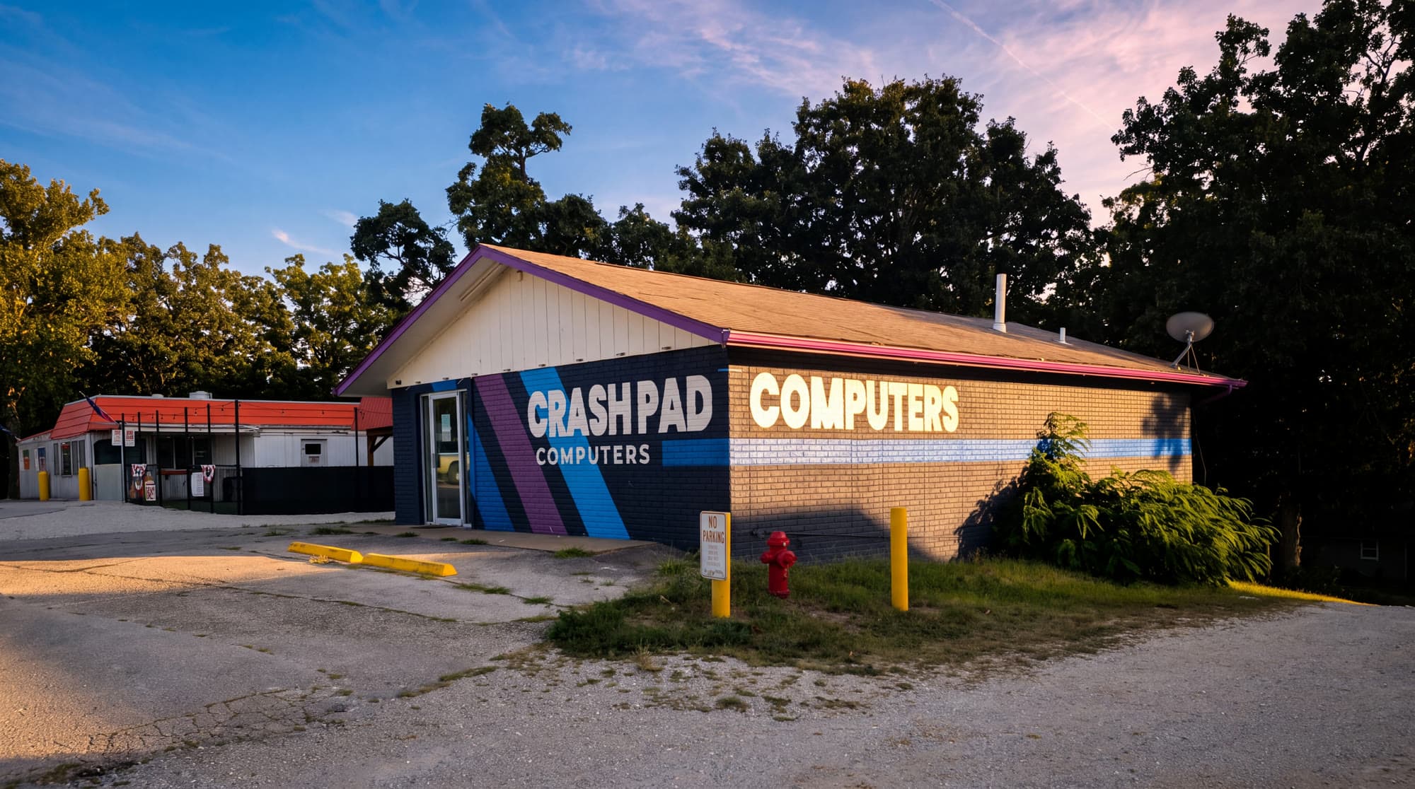 The Crash Pad Computers building on 14327 MO-5 — navy brick with the painted stripe mural — about 10 minutes from Laurie.